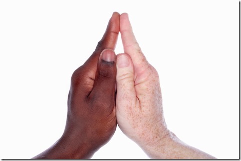 Two hands of different races together form the shape of a church with a steeple (as in the childs hand game) symbolic for unity and racial harmony within the church