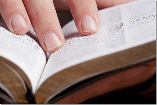 Fingers on open Bible