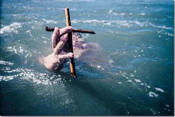 Man holding cross in the sea